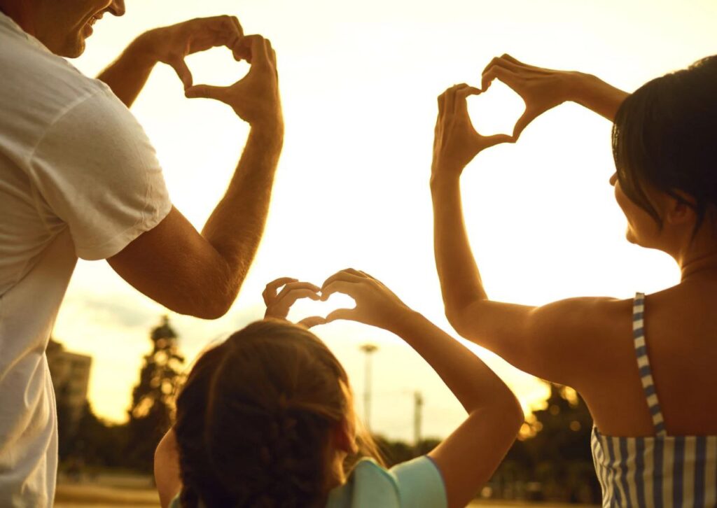 papa, mama e hija hacen corazones con sus manos